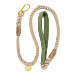 The Found My Animal Waxed Cotton Canvas Leash Collection features a beige handcrafted leash with a gold metal clip, brown accent wraps, green fabric handle, and a round gold tag for stylish flair.