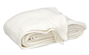 The Matouk Chatham Blanket in Ivory, crafted from 100% cotton with a waffle weave, is made in Portugal and shown folded against a white background.