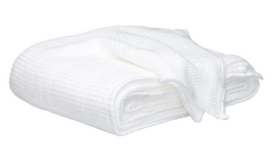 The Matouk Chatham Blanket in white, crafted in Portugal from 100% cotton with a waffle texture, is shown folded against a plain white background.