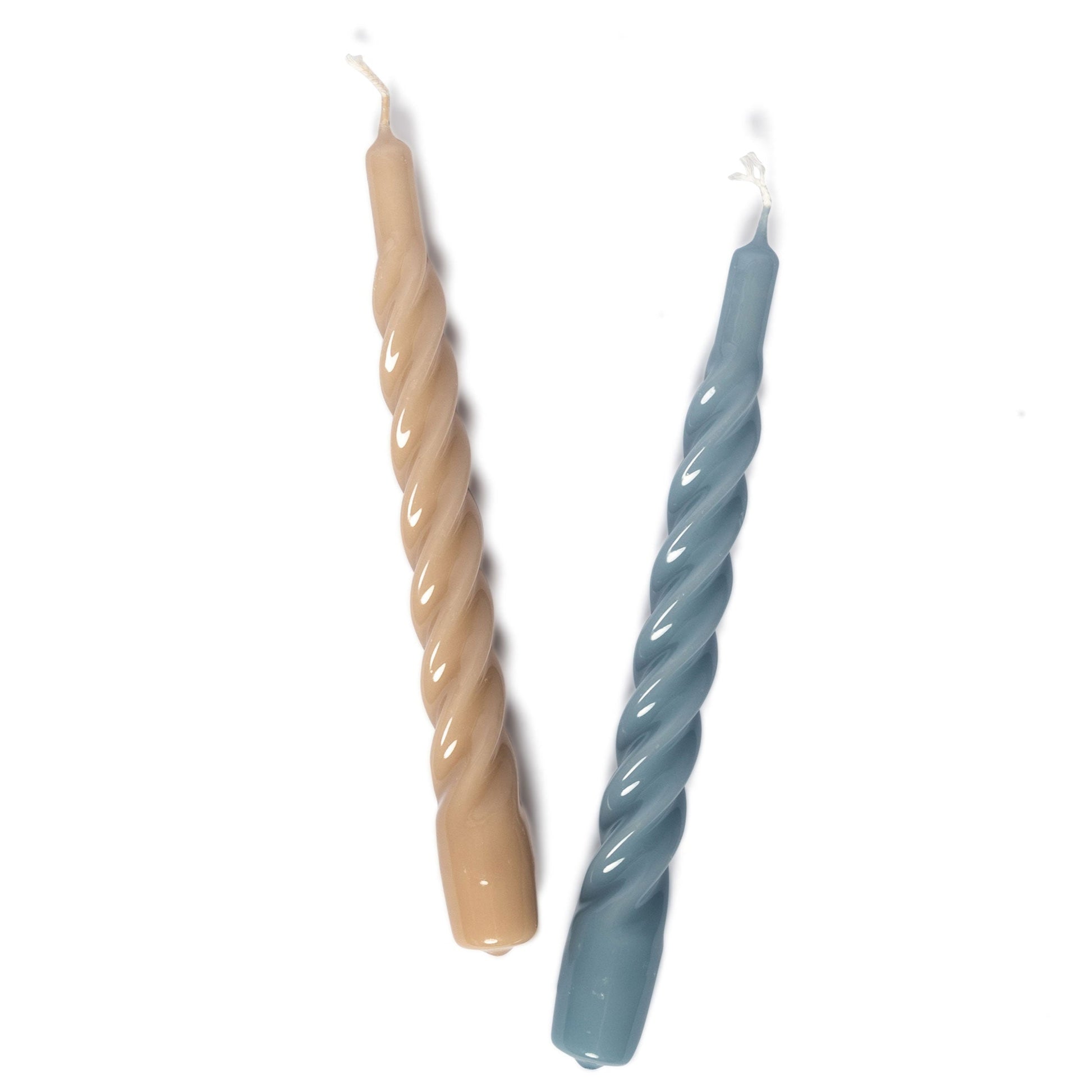 The Chic Gift Hamper by Sharland England features two spiral taper candles, one beige and one blue, placed side by side on a white background—ideal as artisanal gifts or for lovers of hand-poured candles.
