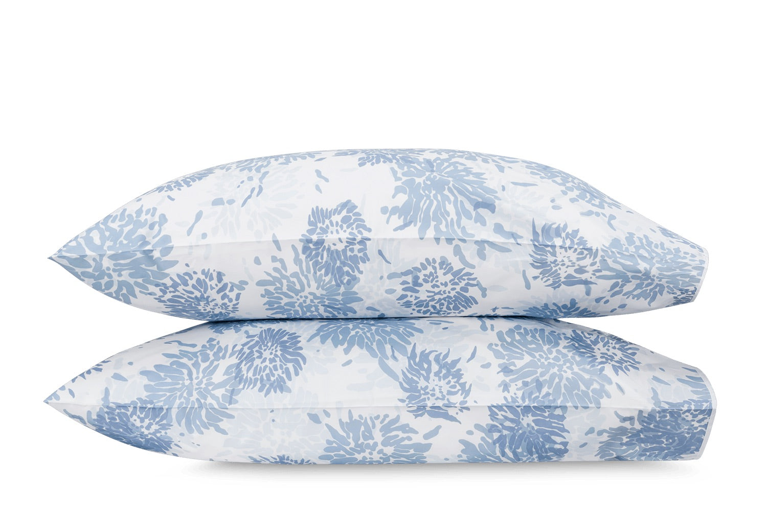 Two white pillows from the Matouk Tillett x Matouk Chrysanthemum Bedding Collection in Blue, featuring blue floral motifs, are stacked against a plain white background.