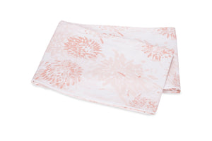 A folded white percale fabric from the Tillett Chrysanthemum Bedding Collection by Matouk, featuring a light pink chrysanthemum floral pattern, laid on a white background.
