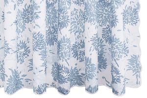 The Chrysanthemum Shower Curtain Collection by Matouk features slightly sheer white fabric with a repeating blue chrysanthemum motif in the Tillett style, designed to hang in gentle folds.