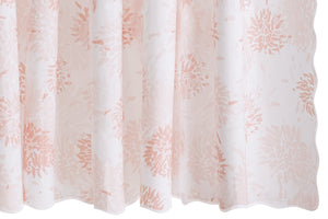 The Matouk Chrysanthemum Shower Curtain Collection features semi-sheer white curtains with a light pink floral motif, Tillett-inspired style, soft folds, and scalloped bottom edges.