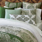 A neatly made bed featuring green and white pillows, a quilted green throw pillow, the John Robshaw Cinde Sage Bedding Collection comforter set, and a soft organic sheet set for an inviting touch.