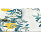 A folded Matouk Citrus Garden Pool Collection linen tablecloth featuring a printed pattern of yellow lemons, green leaves, and blue foliage.