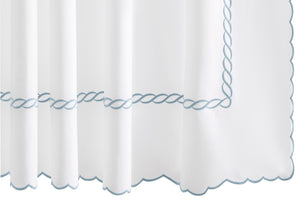The Classic Chain Scallop Shower Curtain Collection by Matouk features white fabric accented with scalloped edges and delicate light blue chain embroidery in a twisted rope pattern along the border, evoking a subtle Greek motif—an elegant addition to your bathroom décor.