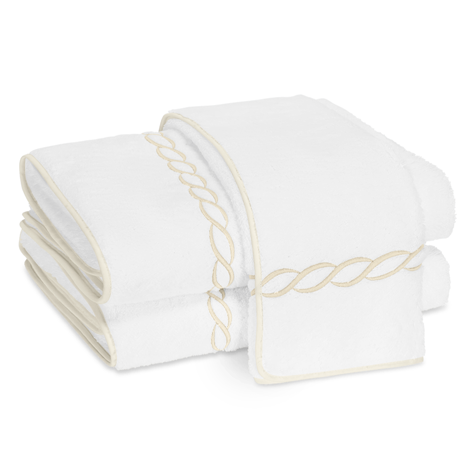 Two folded Matouk Classic Chain Bath Collection towels in Cairo cotton terry, featuring beige chain embroidery and matching trim, displayed on a white background.