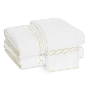 Two folded Matouk Classic Chain Bath Collection towels in Cairo cotton terry, featuring beige chain embroidery and matching trim, displayed on a white background.