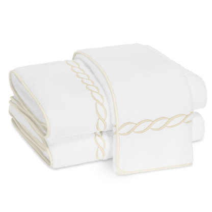 Two folded Matouk Classic Chain Bath Collection towels in Cairo cotton terry, featuring beige chain embroidery and matching trim, displayed on a white background.