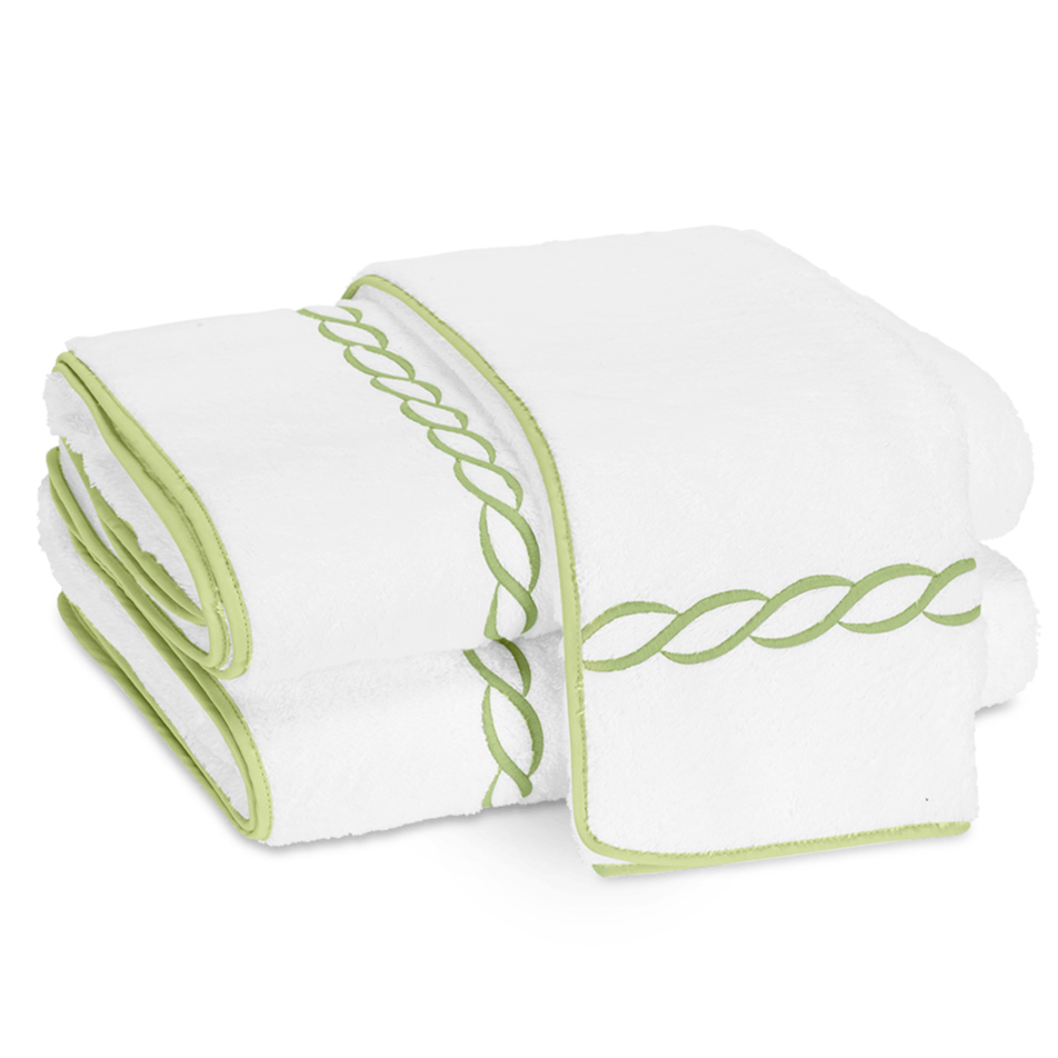 Two folded Matouk Classic Chain Bath Collection cotton terry towels with light green trim and a signature chain embroidered border, displayed side by side on a plain background.