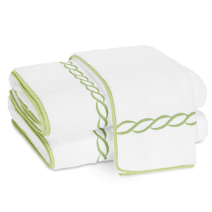 Two folded Matouk Classic Chain Bath Collection cotton terry towels with light green trim and a signature chain embroidered border, displayed side by side on a plain background.