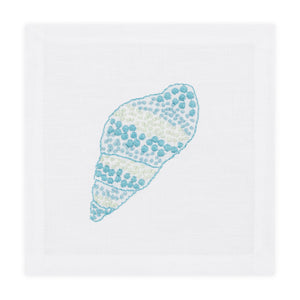 The Speckled Conch Coaster Set by Haute Home is a white linen coaster set with a hand embroidered blue and green seashell design in the center.