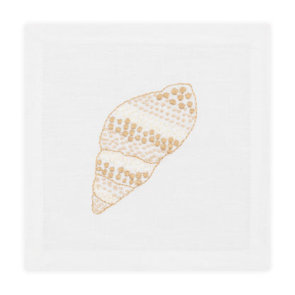 The Haute Home Speckled Conch Coaster Set features white cloth napkins with embroidered beige and gold seashells, perfectly complementing the elegant coasters for a refined table setting.
