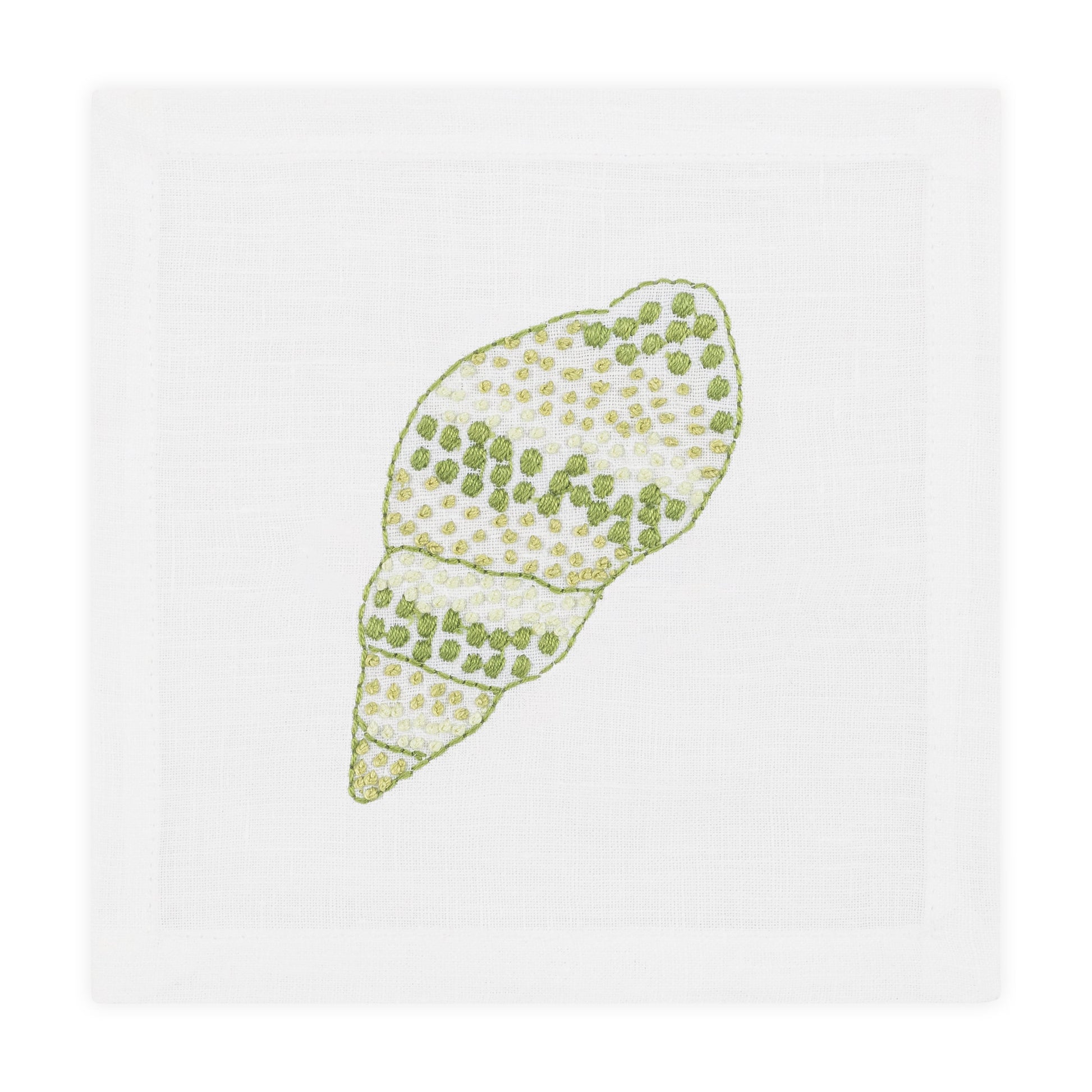 The Haute Home Speckled Conch Coaster Set features hand embroidery and pairs perfectly with a white napkin accented by a green and white seashell design for a coordinated tabletop look.