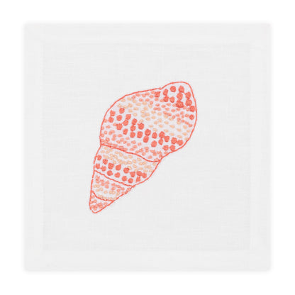Haute Home’s Speckled Conch Coaster Set pairs perfectly with a white cloth napkin featuring an embroidered orange and pink seashell for a stylish, coastal-inspired table setting.