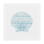 The Haute Home Speckled Shell Coaster Set features hand-embroidered light blue seashell designs on white Italian linen coasters.