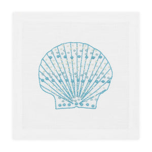 The Haute Home Speckled Shell Coaster Set features hand-embroidered light blue seashell designs on white Italian linen coasters.
