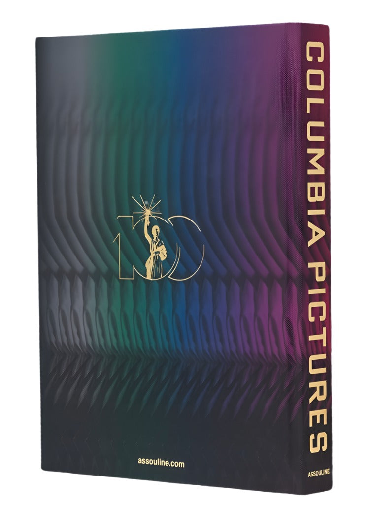 A hardcover book titled "Columbia Pictures" by Assouline features a gradient design and a logo on the cover. Celebrating 100 Years of Cinema, it delves into film history with remarkable detail, and the publisher's website, assouline.com, is printed at the bottom.