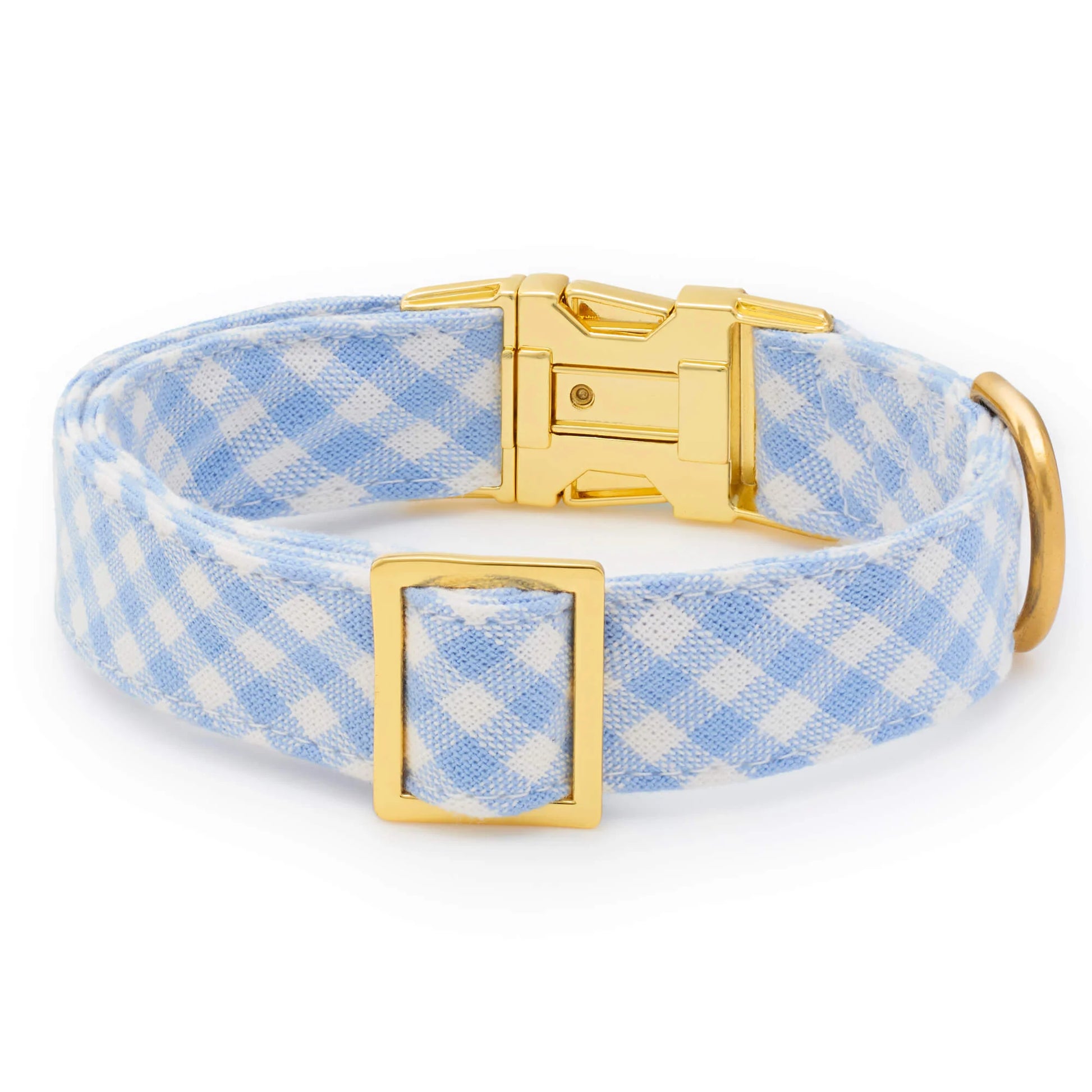 The Foggy Dog's Sky Blue Gingham Spring Dog Collar features a white plaid pattern with a gold buckle, slider, and D-ring, shown on a white background.