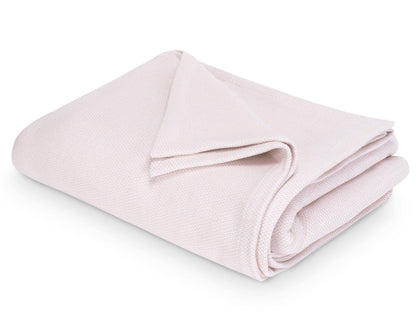 The Costa Mesa Blanket Collection by Matouk features a soft, light pink knitted blanket displayed on a white background.
