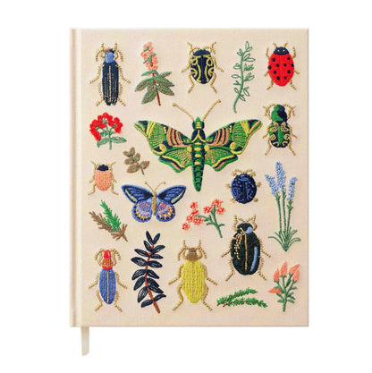 A cream notebook cover from the Riffle Paper Co. Curio Desk Accessory Collection, adorned with illustrated bugs and plants—moths, butterflies, beetles, flowers, and leaves—a perfect gift for garden enthusiasts.
