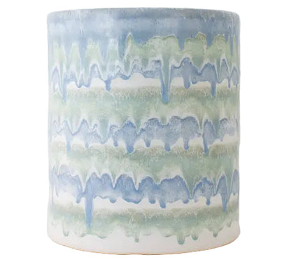 The Cylindrical Garden Stool Collection by Paul Schneider Ceramics features ceramic stools with blue and green drip glaze over white. Each piece is unique, making it a perfect addition to any decor.