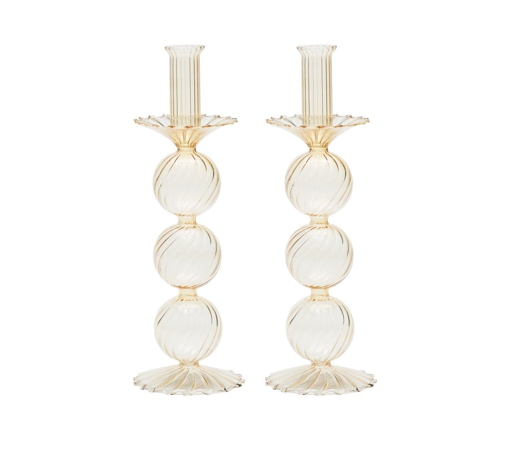 The Kim Seybert Iris Tall Candle Holder Set features two hand-blown glass candlesticks with a ribbed texture, three stacked spheres, and scalloped bases, shown against a white background.