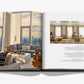 An open copy of "The Living Room" by Assouline shows modern, stylish living rooms with large windows and city views, accompanied by descriptive design text.