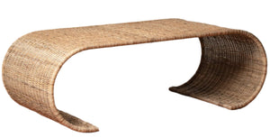The Healdsburg Wicker Coffee Table by Selamat features a curved, continuous form with open arches at each end, crafted from sustainably harvested rattan for a stylish and eco-friendly centerpiece.