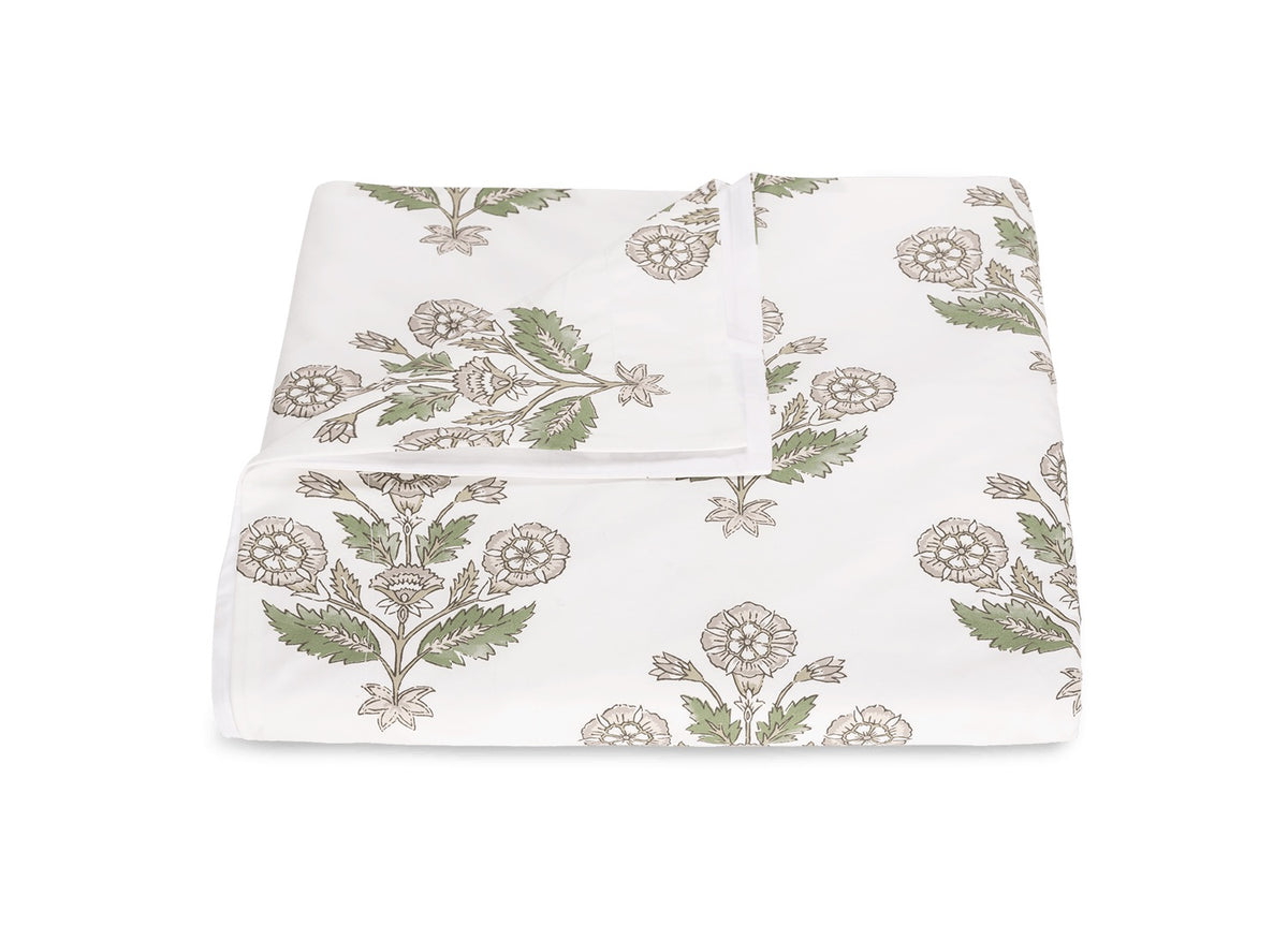 A neatly folded bedsheet from the Dalila Bedding Collection by Matouk, featuring a vibrant green and beige floral pattern inspired by Schumacher block print, displayed on a plain white background.