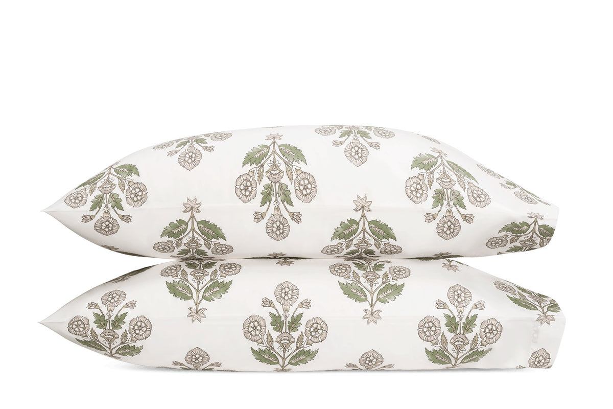 Two pillowcases from the Dalila Bedding Collection by Matouk, featuring a vibrant green and taupe botanical pattern inspired by a Schumacher block print, are stacked together against a plain white background.