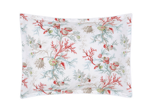 The Matouk Del Tesoro Bedding Collection, Coral, features a white pillowcase adorned with vibrant sea life motifs—red coral, seashells, and marine creatures—adding a lively oceanic touch to your decor.