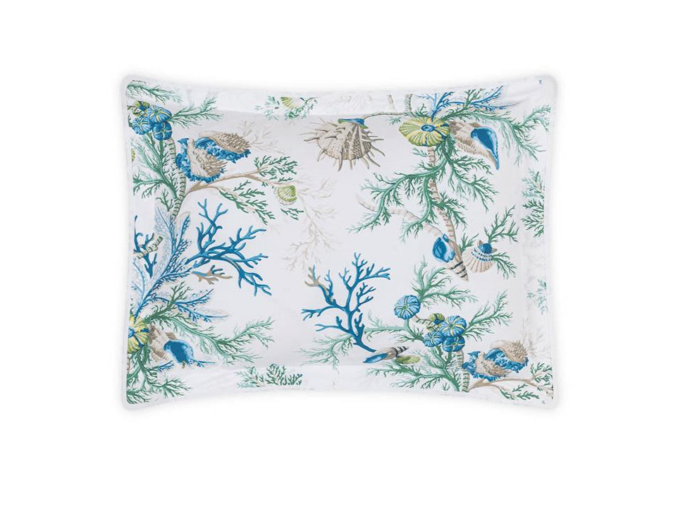 The Matouk Del Tesoro Bedding Collection, Sea, features a rectangular pillowcase with a white background and an oceanic fantasy pattern of blue, green, and beige corals, shells, and maritime creatures.