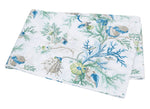 Immerse yourself in the Del Tesoro Bedding Collection by Matouk, featuring folded fabric adorned with a marine-themed print of blue and green shells, seaweed, and coral on a crisp white background—capturing an oceanic fantasy teeming with graceful maritime creatures.