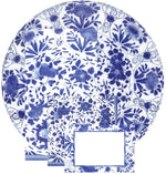 Caspari’s Delft Blue Napkin Collection features biodegradable napkins with blue and white floral patterns, beautifully paired with a round porcelain plate and a place card accented by a blue border.