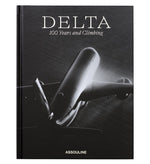 Black-and-white cover with a large airplane seen from below; "Delta: 100 Years and Climbing" celebrates Delta Air Lines’ centennial. Published by Assouline, this striking book chronicles the airline's 100-year history.