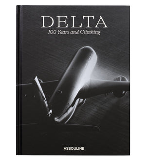 Black-and-white cover with a large airplane seen from below; "Delta: 100 Years and Climbing" celebrates Delta Air Lines’ centennial. Published by Assouline, this striking book chronicles the airline's 100-year history.