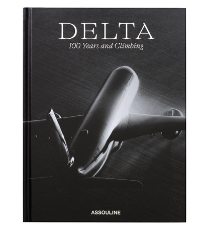 Black-and-white cover with a large airplane seen from below; "Delta: 100 Years and Climbing" celebrates Delta Air Lines’ centennial. Published by Assouline, this striking book chronicles the airline's 100-year history.