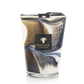 A decorative Baobab Collection Delta Nil candle in a glass container with swirling blue and white patterns, isolated against a black background.