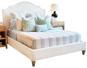 Dome Queen Bed by Lee Industries featuring a modern curved headboard, styled with a blue and white striped quilt and assorted decorative pillows.
