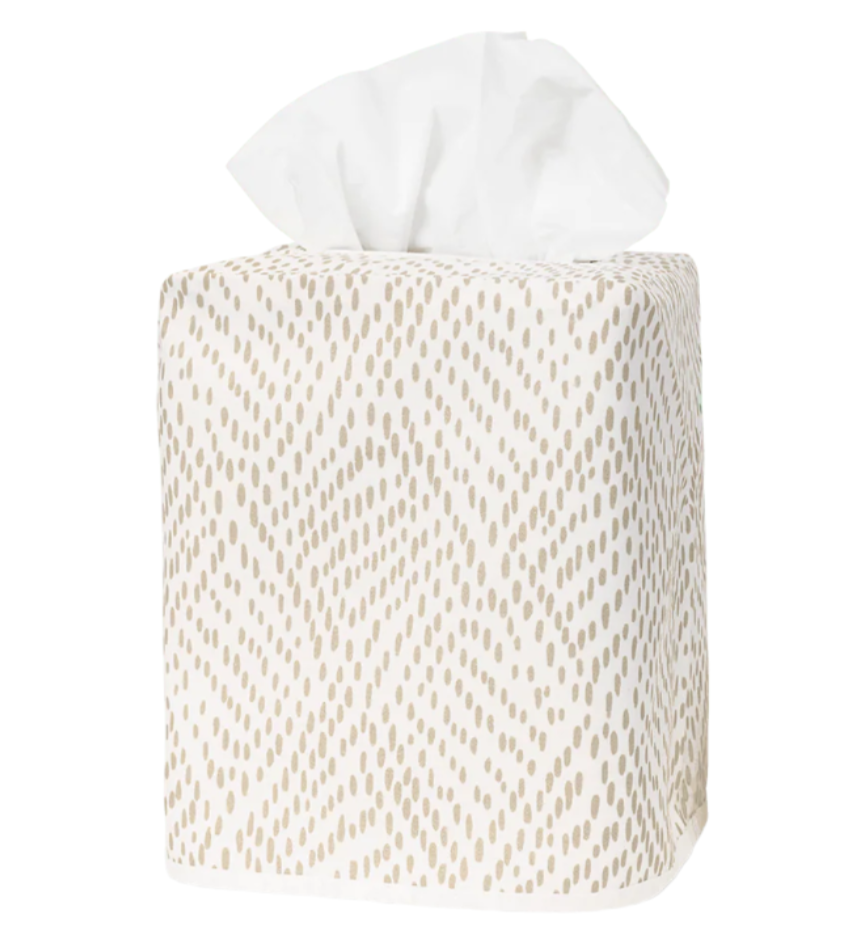 The Matouk Duma Diamond Dune Tissue Box Cover is a square cover with a beige geometric pattern, crafted from Egyptian cotton percale, and displays a few tissues emerging from the top.