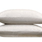 Two beige decorative pillows from the Matouk Duma Diamond Bedding Collection, featuring a subtle geometric pattern inspired by a classic Schumacher design, are stacked on top of each other against a white background.