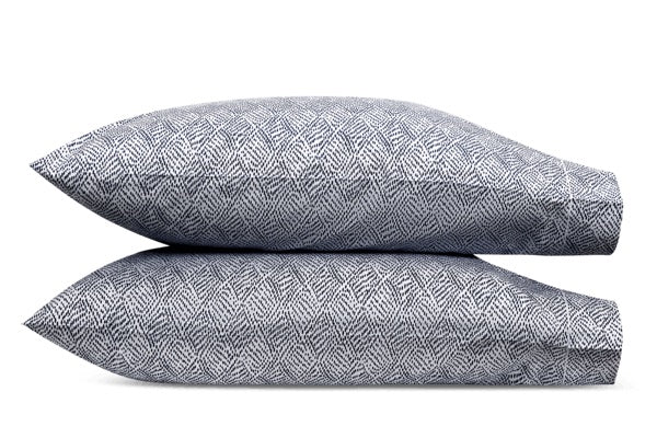 Two gray pillows from the Duma Diamond Bedding Collection by Matouk, featuring a subtle geometric pattern in luxurious Egyptian cotton percale, are stacked horizontally against a white background.