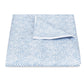 The Matouk Duma Diamond Bedding Collection is shown folded on a plain white background, highlighting its subtle blue and white harlequin pattern.
