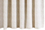 The Duma Diamond Dune Shower Curtain by Matouk features a beige and white geometric pattern inspired by Schumacher, hanging in soft, even folds.