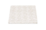 The Duma Diamond Bedding Collection by Matouk features a folded, beige and white textured fabric with a geometric diamond pattern in the Schumacher-inspired style, elegantly displayed on a white background.