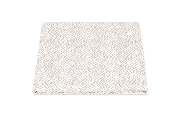 The Duma Diamond Bedding Collection by Matouk features a folded, beige and white textured fabric with a geometric diamond pattern in the Schumacher-inspired style, elegantly displayed on a white background.