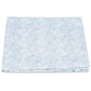 A folded cloth from the Duma Diamond Bedding Collection by Matouk, showcasing a striking white and blue geometric Schumacher-inspired pattern, is displayed against a plain white background.