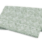 The Duma Diamond Bedding Collection by Matouk is displayed against a plain background, featuring folded white Egyptian cotton percale adorned with a green, leaf-like dotted geometric pattern.